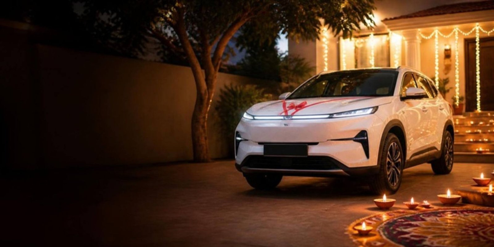 A new SUV outside a home lit with diyas and fairy lights for Diwali